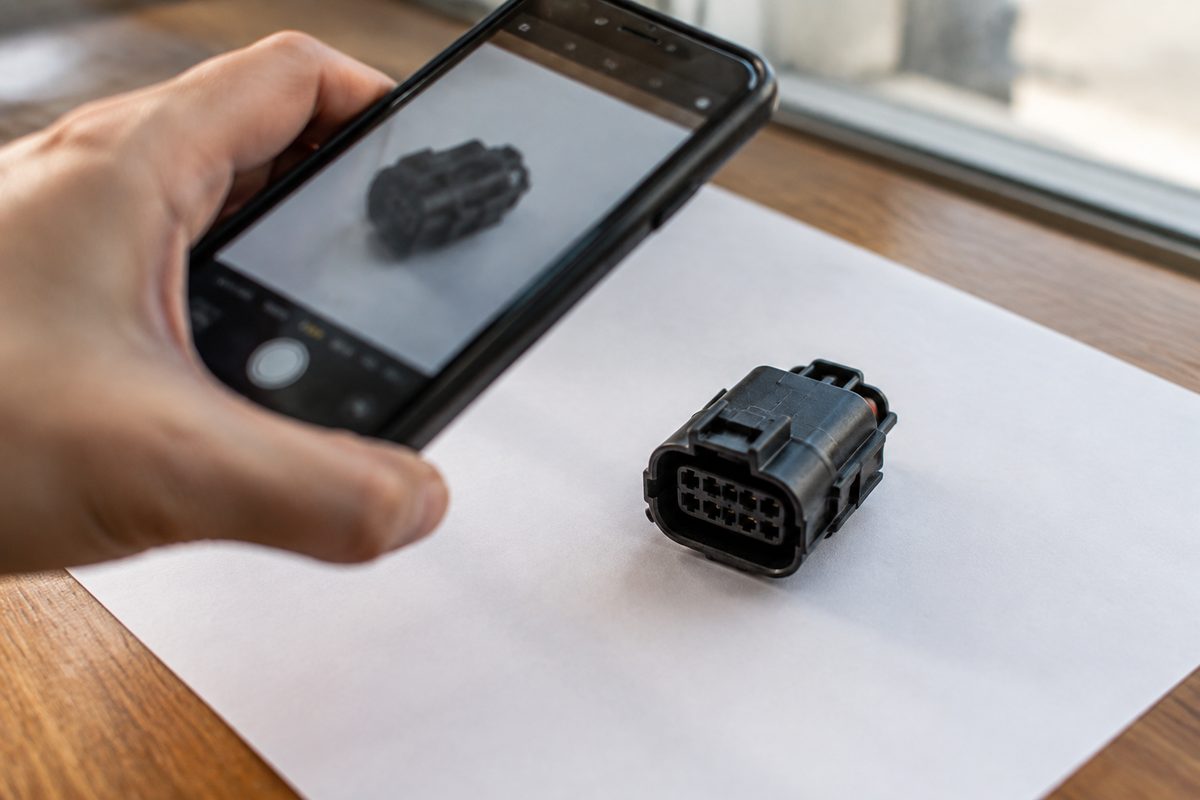 A phone positioned to photograph an automotive connector